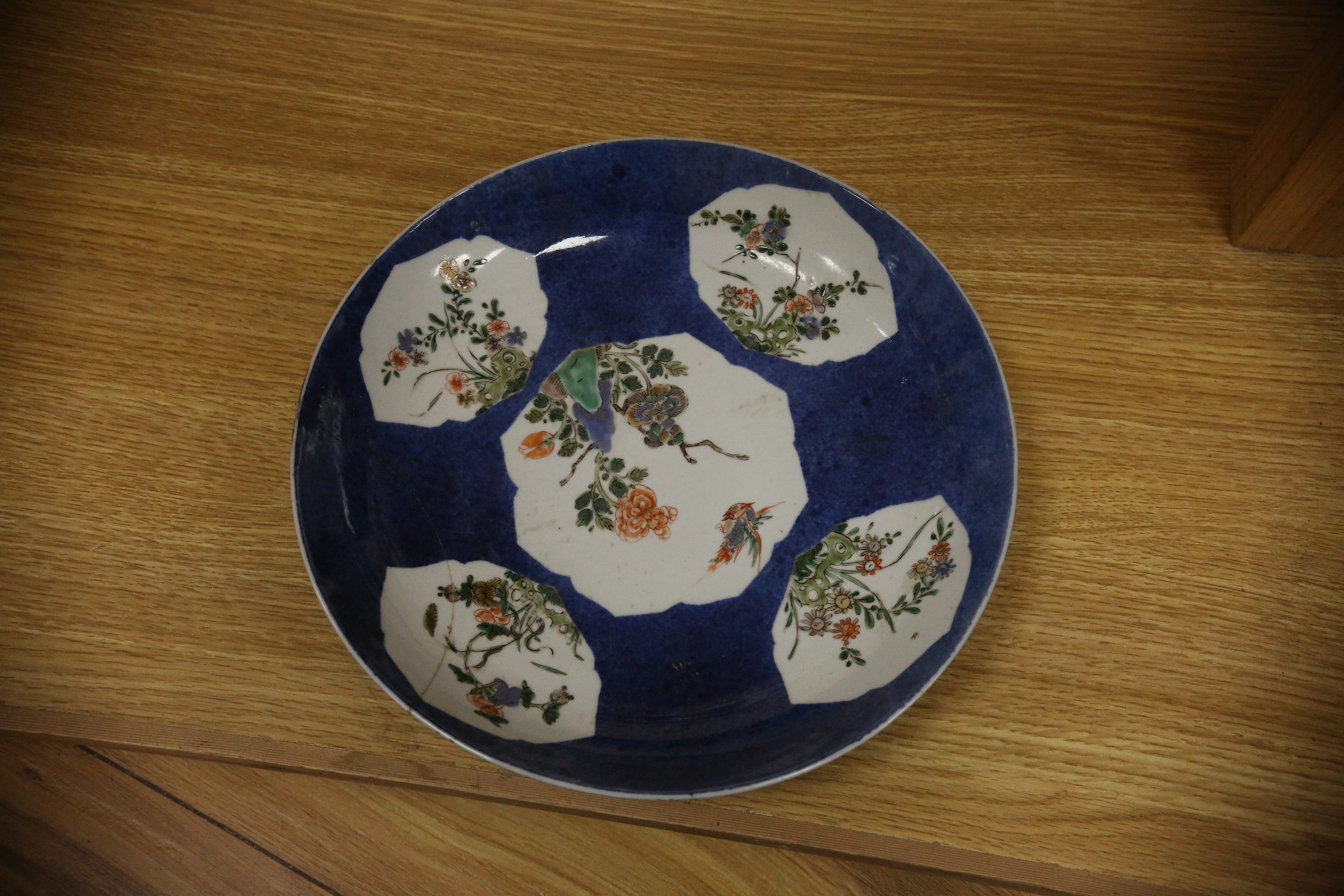 A Chinese famille verte powder blue ground bowl and a similar dish, both Kangxi period, 27.5cm diameter. Condition - dish poor, bowl fair